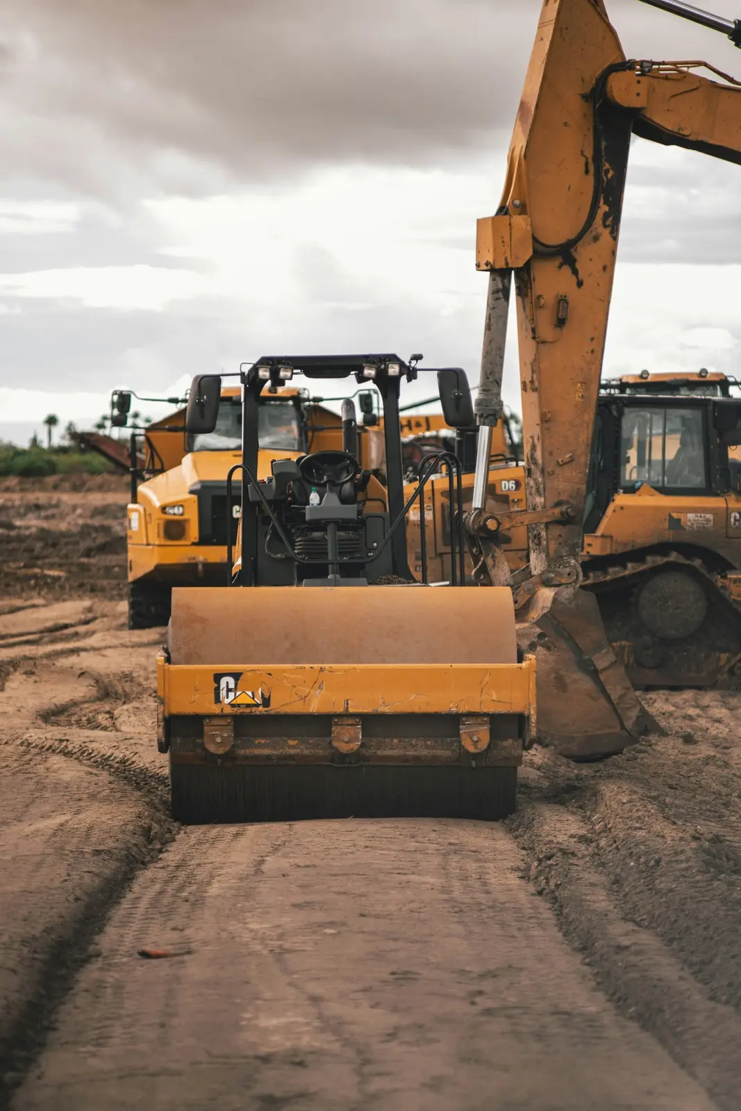 Roller and excavator on a dirt job site