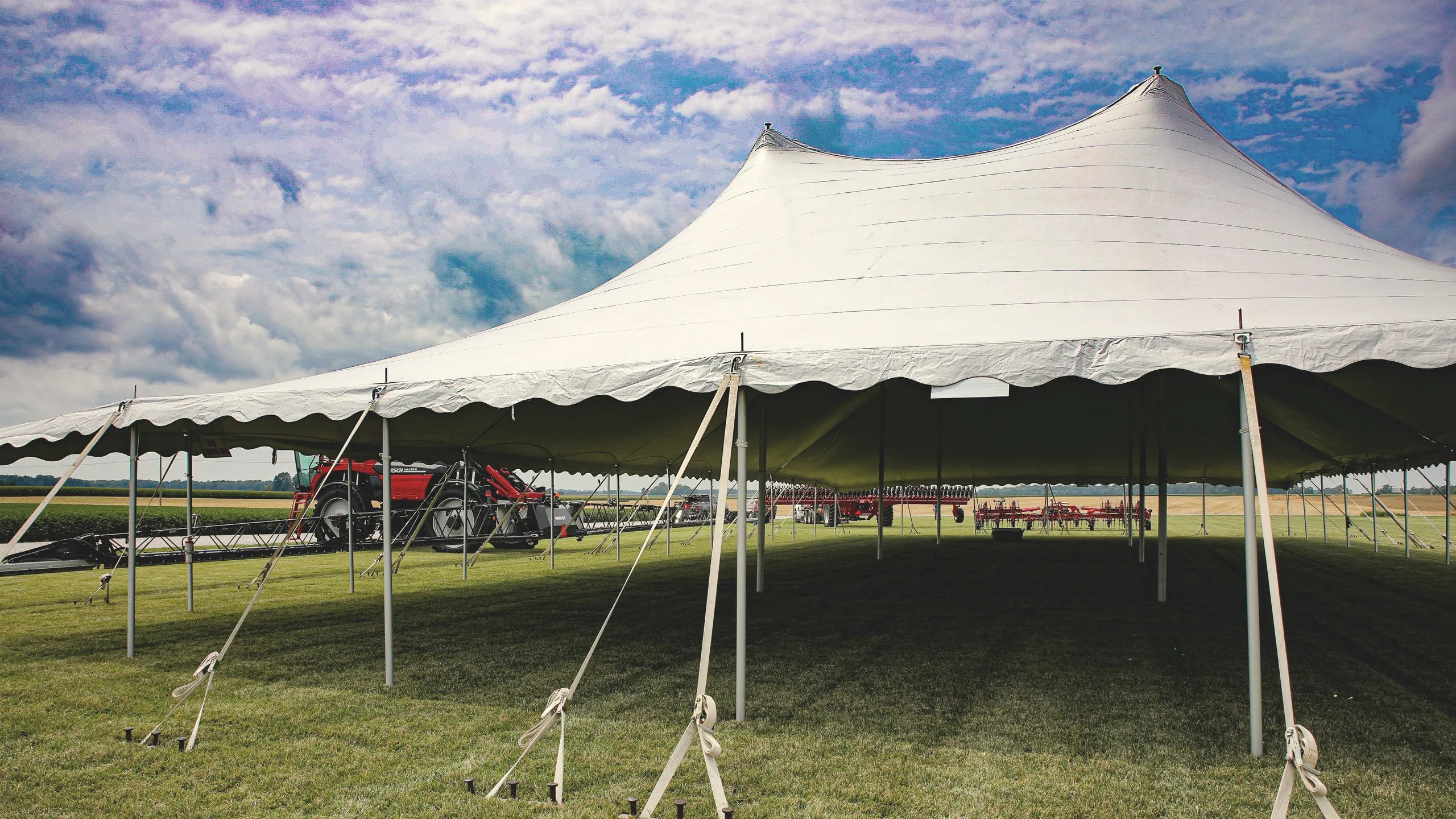 White event tent on grass under a blue sky